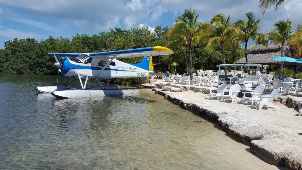 a small airplane is parked on the side of a lake