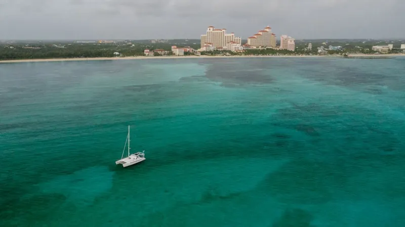 Bahamas Catamaran floating near resort skyline and turquoise sea.