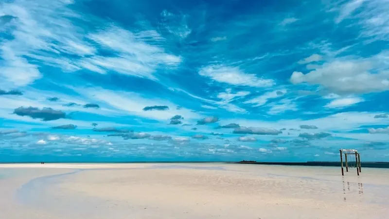 Eleuthera beach with turquoise water, sand, and vivid sky.