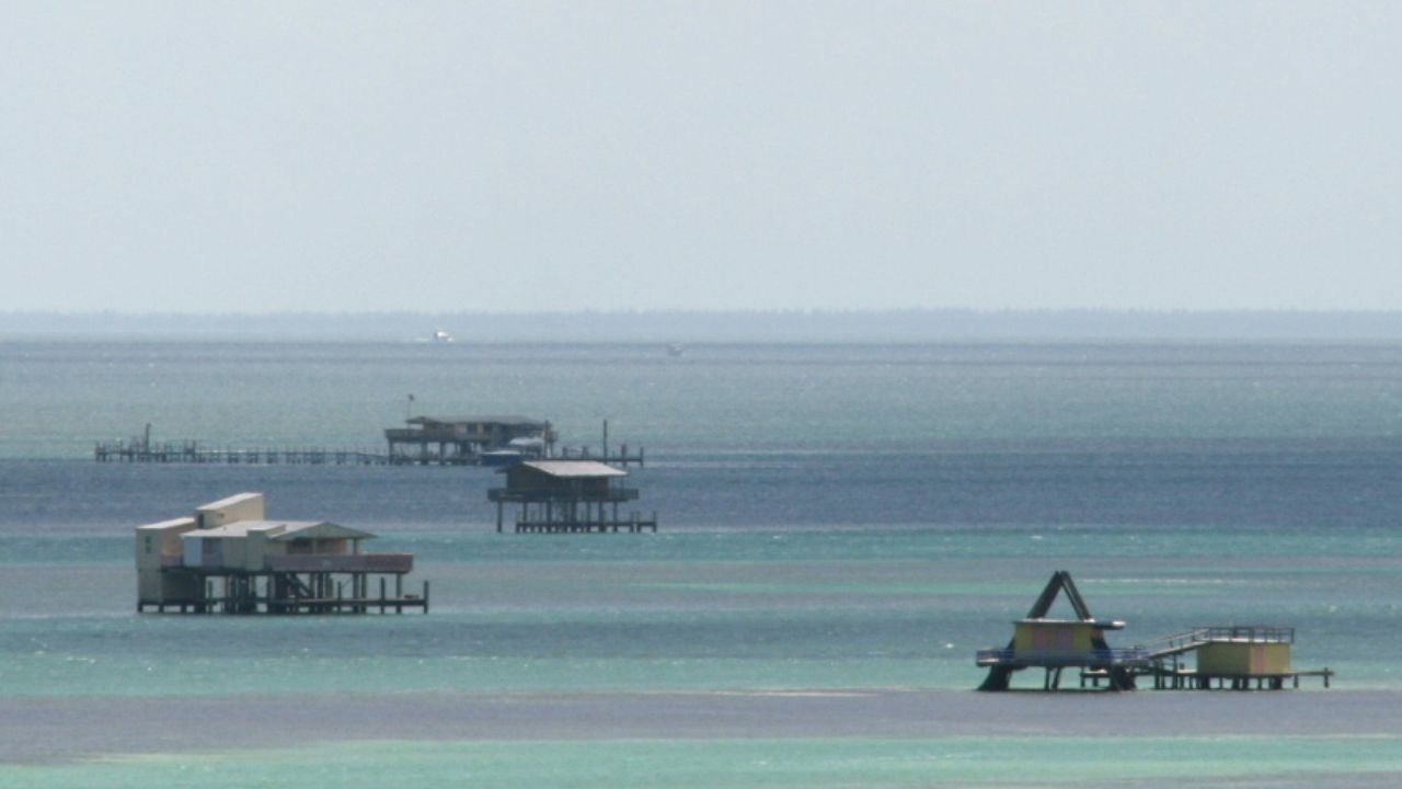 Stiltsville houses on Biscayne Bay over turquoise shallow water. 