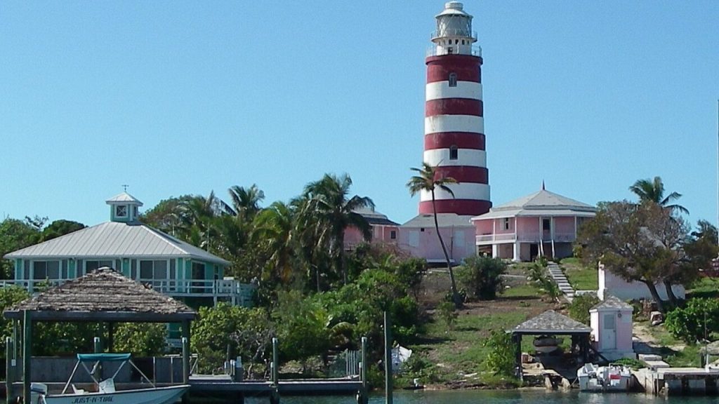 Elbow Cay lighthouse with pastel houses and palm trees.