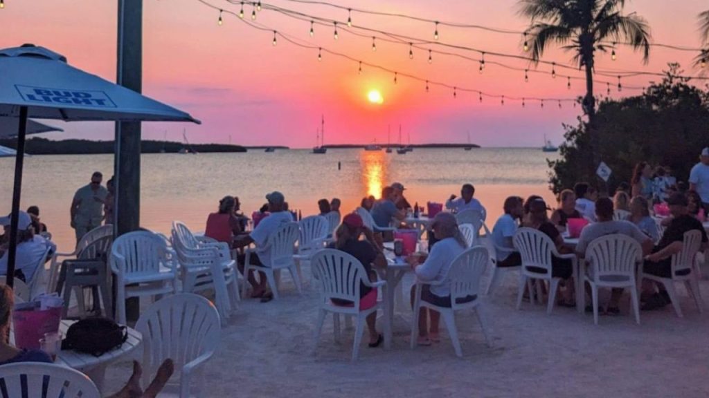 Lorelei Cabana Bar sunset dining with lights and sailboats.